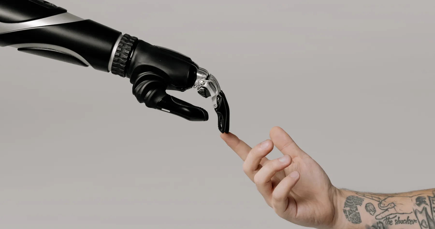 Una mano robótica y una mano humana a punto de tocarse con la punta de los dedos